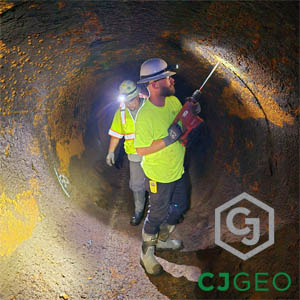 CJGeo worker drilling holes through a metal pipe as part of a penstock void filling project.