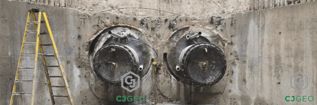 Two ductile iron water intake pipe protruding from tunnel casings inside of a shaft.