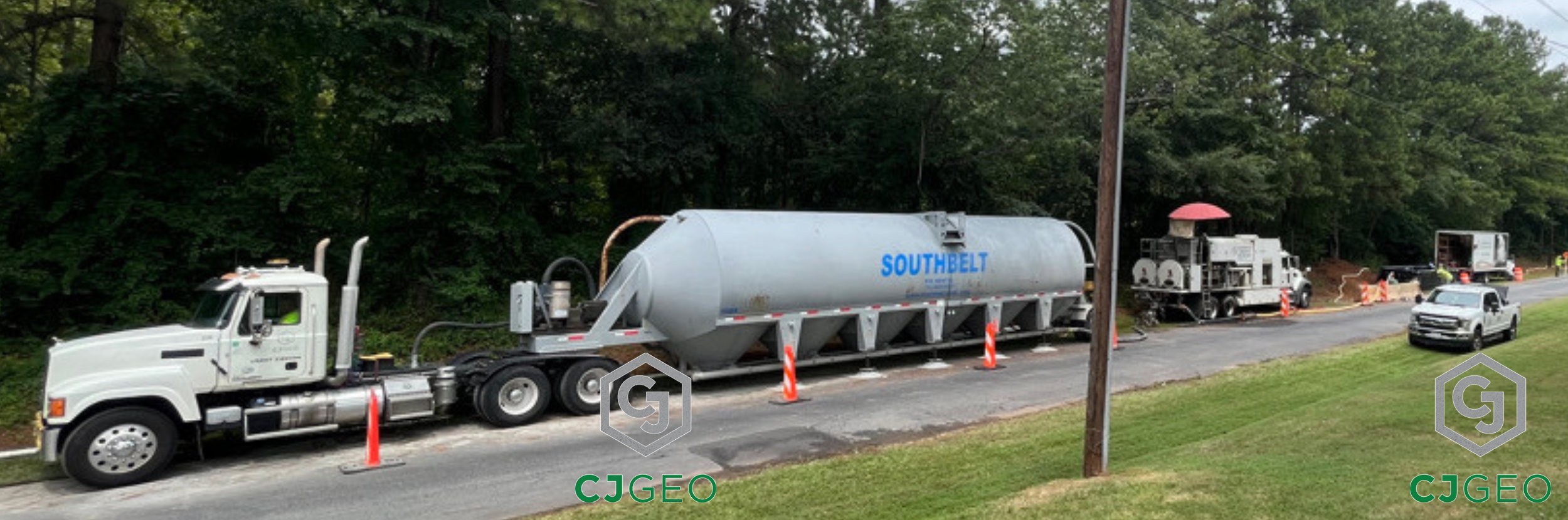 a semi, cement pig, batch plant and pickup truck on a roadside pipe abandonment jobsite