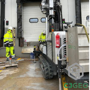 a sonic drill and two drillers next to a warehouse dock