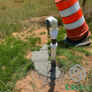 cellular concrete dribbling out of a pipe next to a barrel