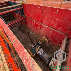 Red trench boxes with a worker and conduits at the bottom.