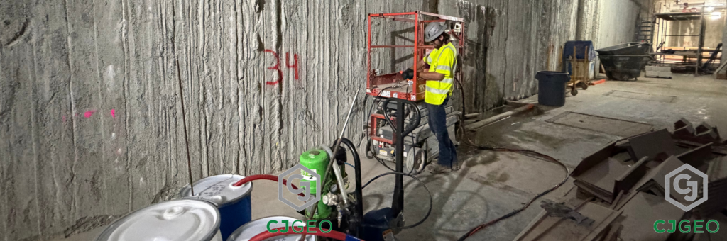 a worker, lift and grouting equipment inside a slurry wall basement