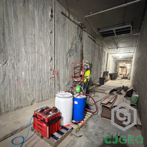 a worker and grouting equipment inside a slurry wall basement